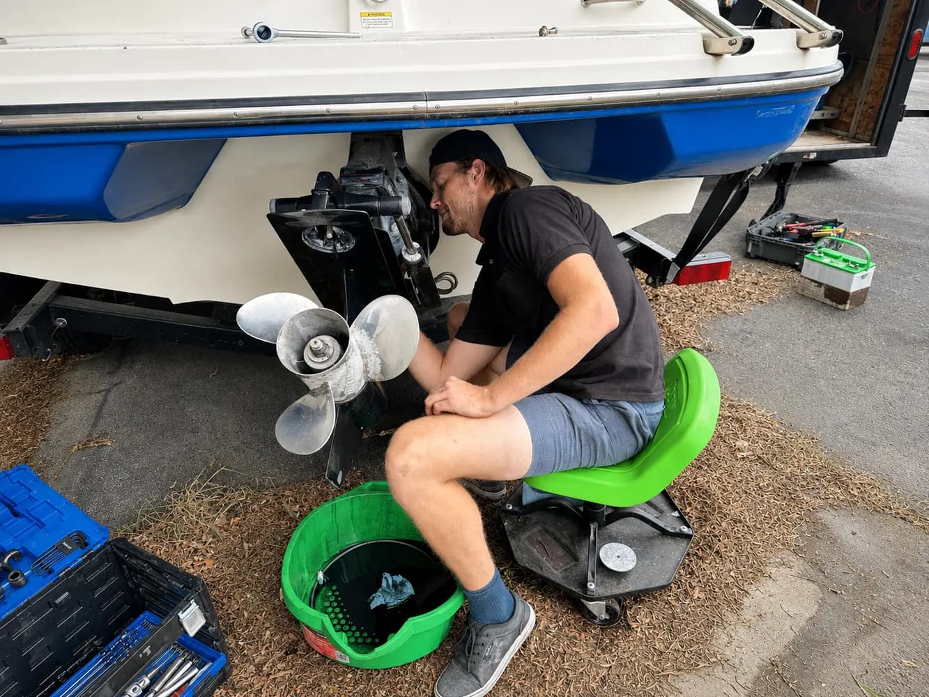 A technician performing hands-on sterndrive maintenance at a customer's location in Utah